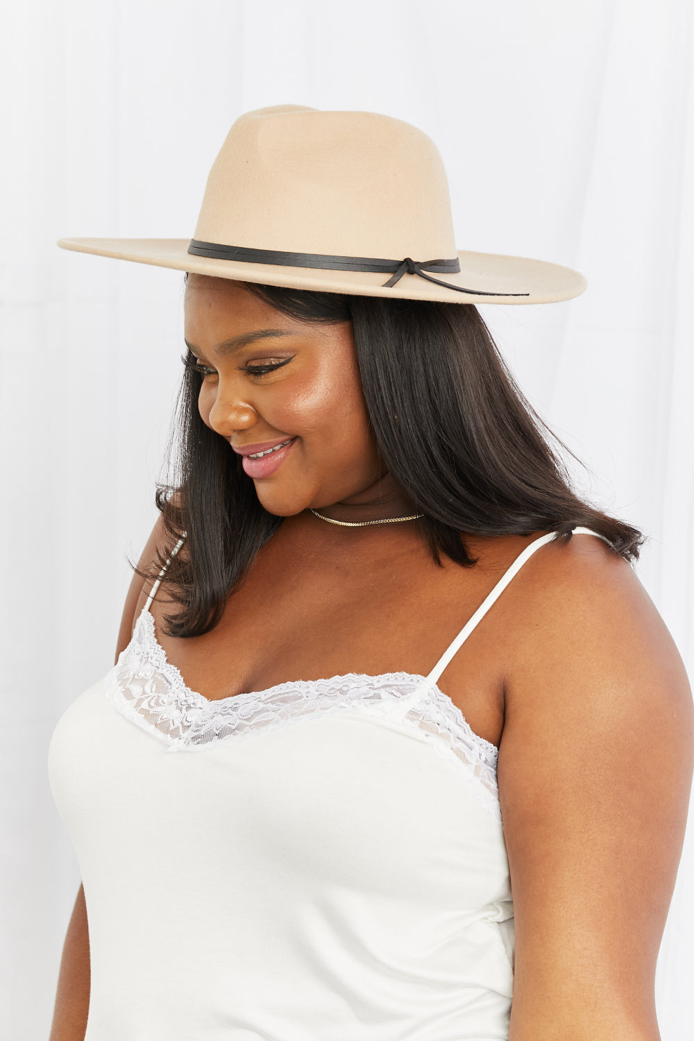 Chic fedora hat for stylish women's fashion, featuring a sleek black band for a modern touch. The hat complements the model's elegant attire, showcasing its versatility for casual or dressy occasions.