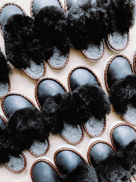 Onyx Black Slip Ons [Limited Edition]
Cozy leather slippers with plush black fur trim, arranged in a stylish pattern.