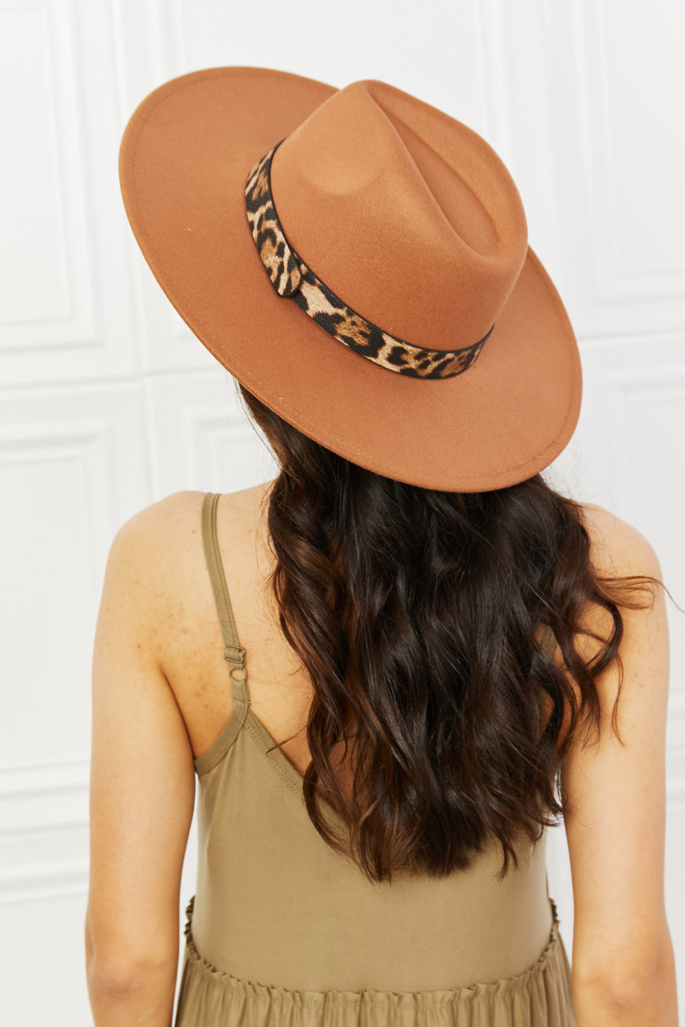 Stylish leopard-accented tan fedora hat with long wavy hair