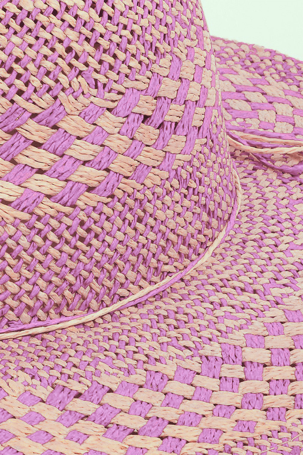 Woven straw sun hat in vibrant purple hues with intricate basket-weave pattern, ready to shield from the sun's rays in style.