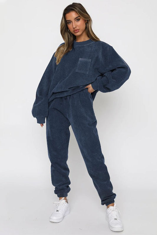 Cozy Corduroy Two-Piece Set: Navy blue cropped top and matching sweatpants styled with casual white sneakers, showcasing a comfortable and stylish loungewear option.