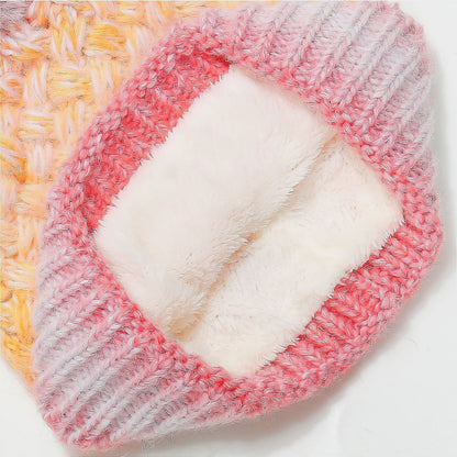 Gradient knit hat with pink and gray stripes and a cozy faux fur pom-pom accent