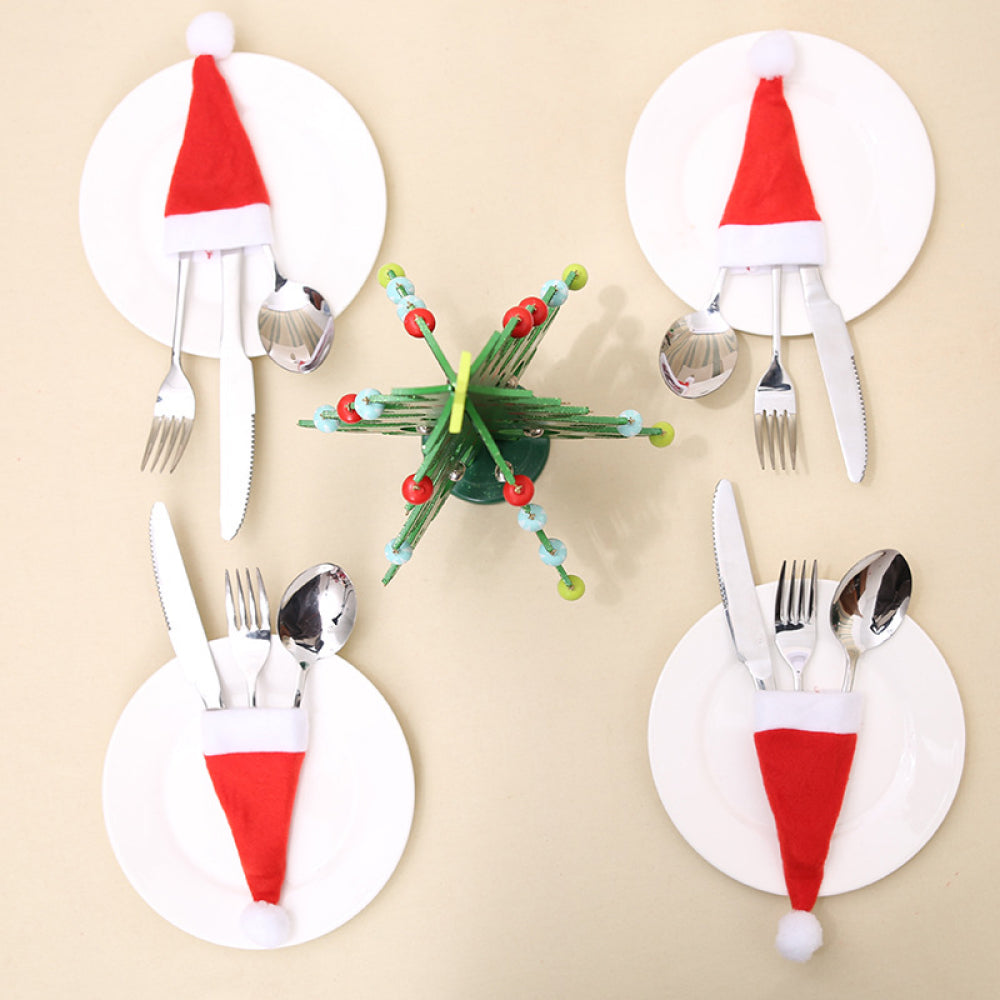 20-Piece Christmas Hat Cutlery Holders - Festive Santa hats adorn white circular holders, each containing a fork, knife, and spoon, arranged on a beige background with a decorative green and red flower-like centerpiece.