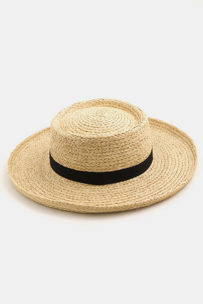 Stylish straw sun hat with wide brim and black ribbon detail, perfect for summer fashion.