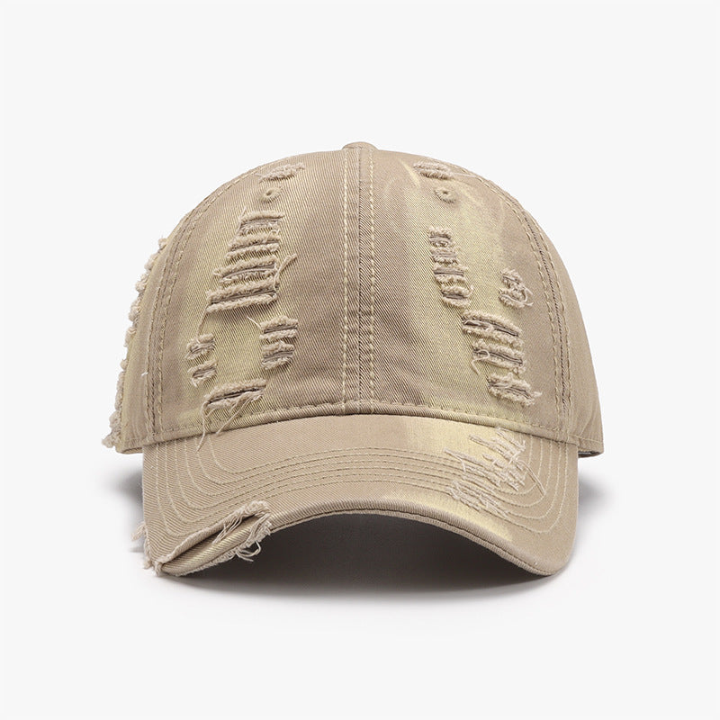 Distressed adjustable cotton baseball cap with a beige tone and a weathered, ripped appearance.