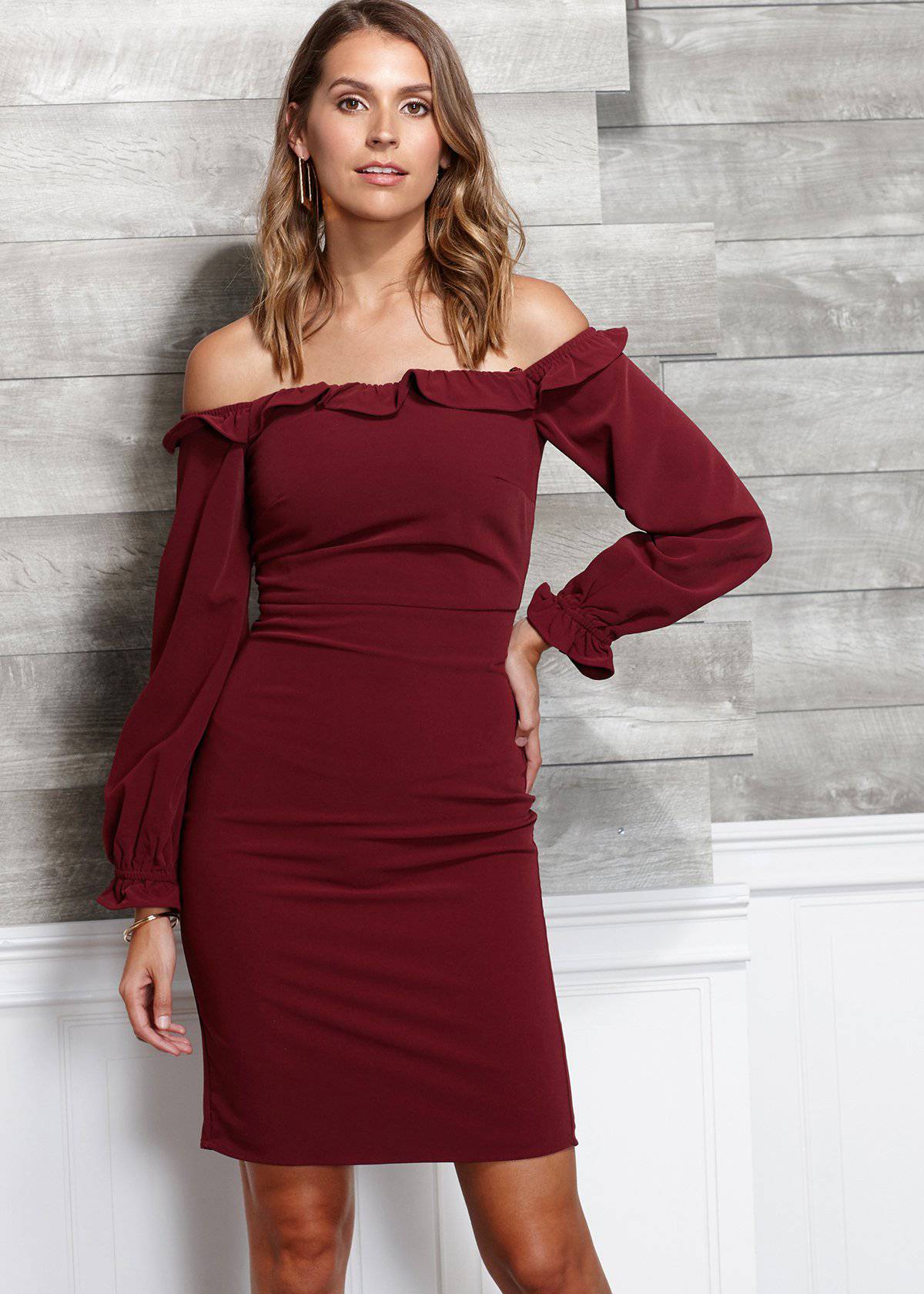 Elegant off-shoulder burgundy bodycon dress with ruffle details, showcasing a stylish model in a minimalist setting.