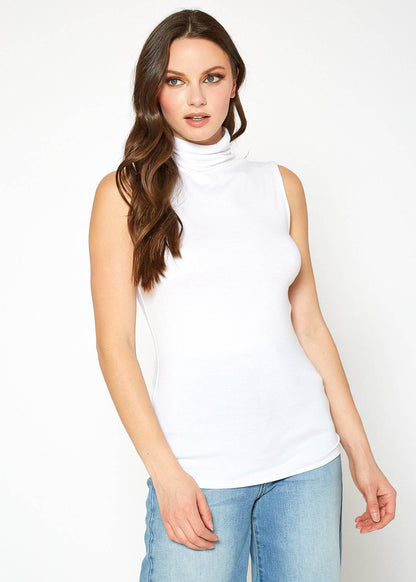 Sleeveless fitted white turtleneck top from Lemon Hera worn by a woman with long wavy brown hair.