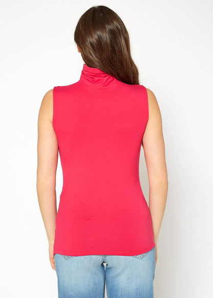 Sleeveless red turtleneck top with fitted silhouette on model with long brunette hair.