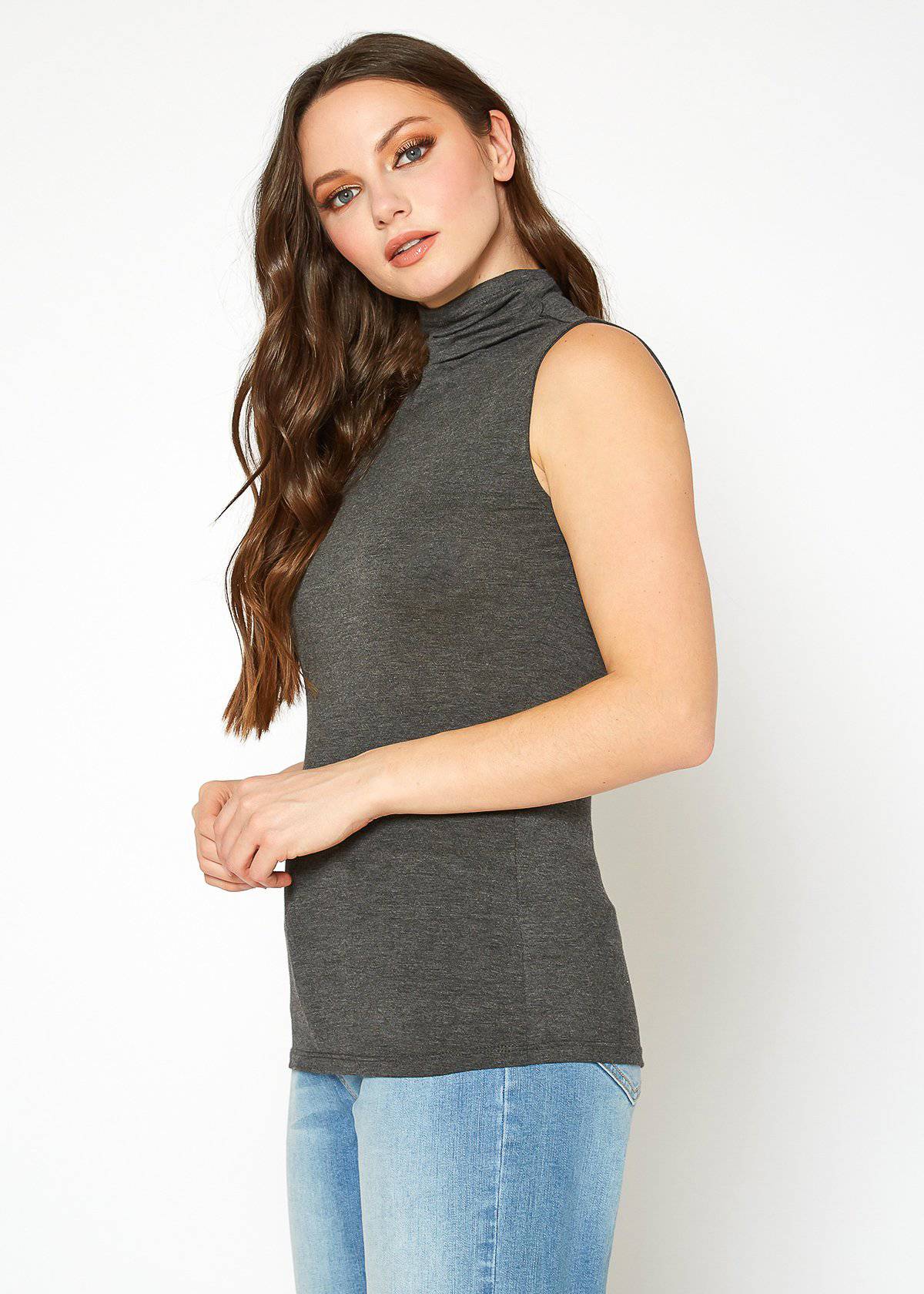 Charcoal gray sleeveless turtleneck fitted top on model with long curly hair