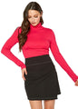 Vibrant pink women's turtleneck top with long sleeves, worn with a black mini skirt.