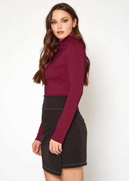 Stylish burgundy turtleneck top with fitted silhouette showcased in model image