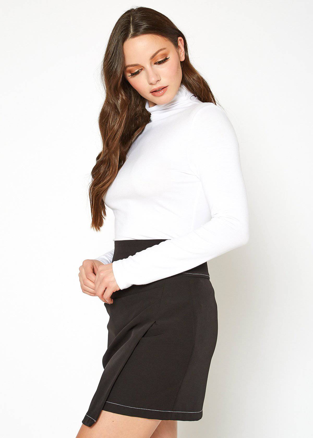 Fitted white turtleneck top with long sleeves, worn by a young woman with long brown hair, posing against a plain white background.