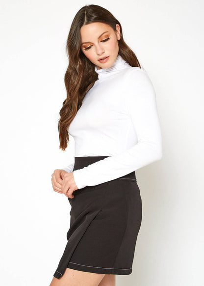 Fitted white turtleneck top with long sleeves, worn by a young woman with long brown hair, posing against a plain white background.