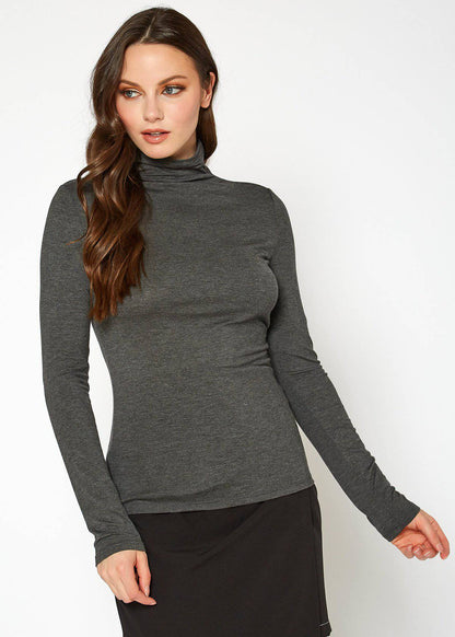 A woman wearing a fitted gray long-sleeve turtleneck top