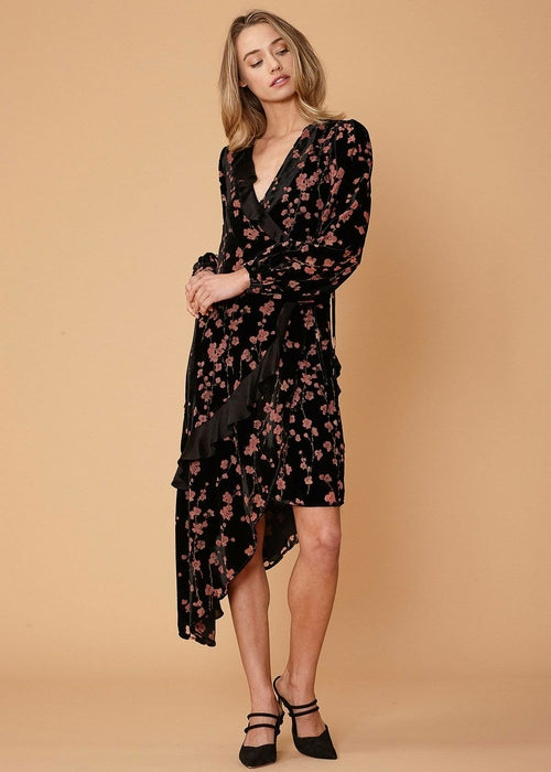 Elegant floral velvet dress with asymmetric wrap design, featuring long sleeves and a romantic floral pattern.