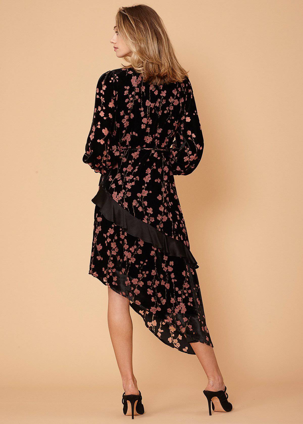 Elegant floral print dress with asymmetric wrap design and billowing sleeves.