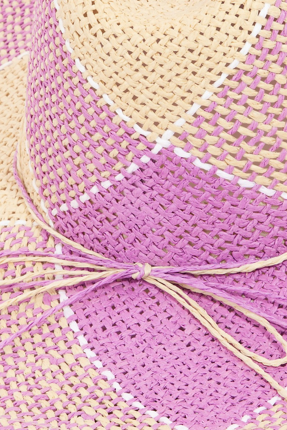 Woven straw hat with contrasting pink and cream patterns, showcasing its intricate textured design.