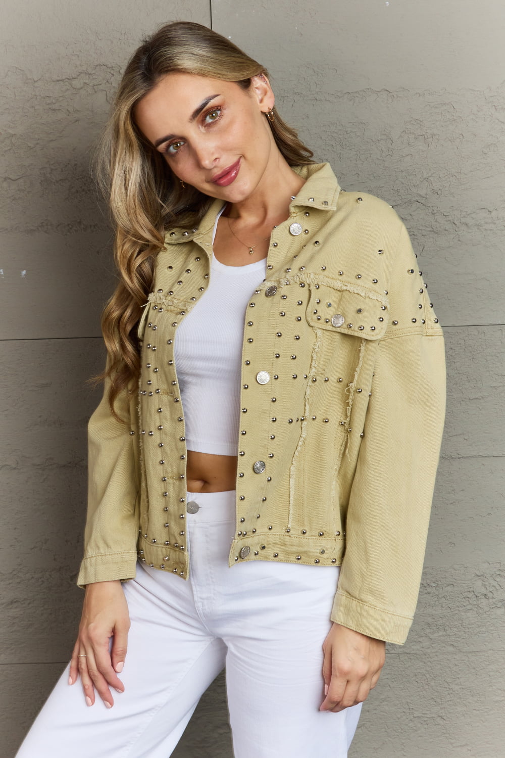 Studded casual denim jacket featuring frayed trim and rivet details.