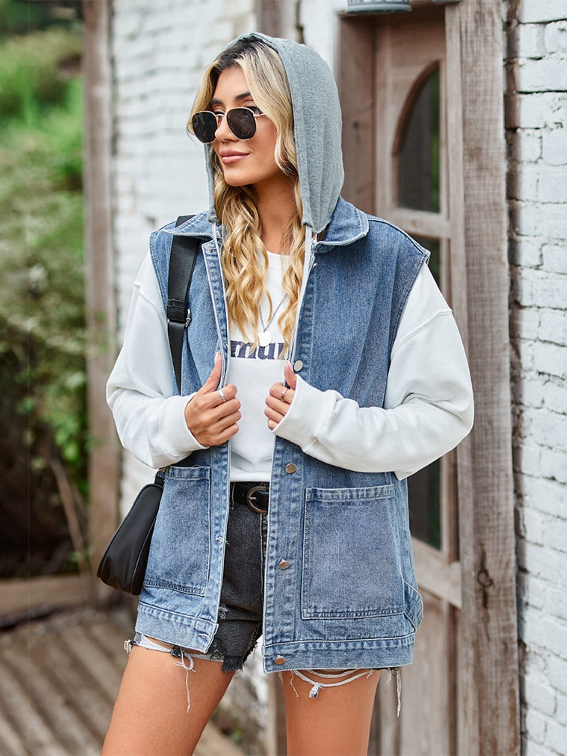 Stylish denim jacket with hoodie, sunglasses, and casual fashion attire.