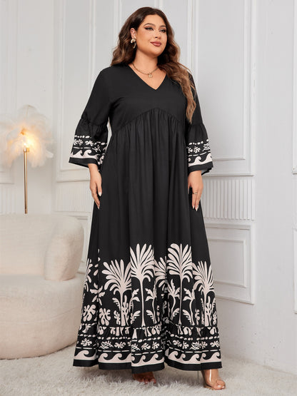 Elegant plus size black and white printed v-neck long sleeve maxi dress with floral and leaf motifs for the stylish woman.