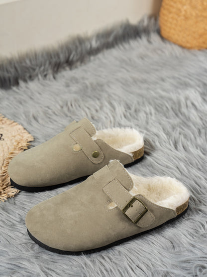 Cozy suede round toe slippers with fur lining, resting on a soft gray shag rug