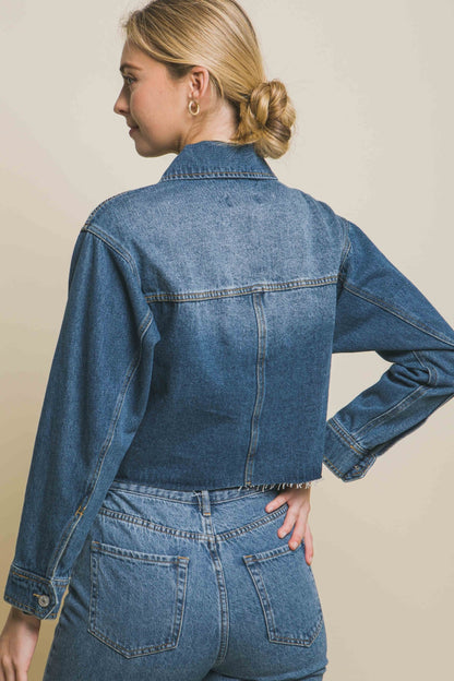 Stylish denim jacket with raw hem and button-up design, worn by young female model with blonde hair in bun.