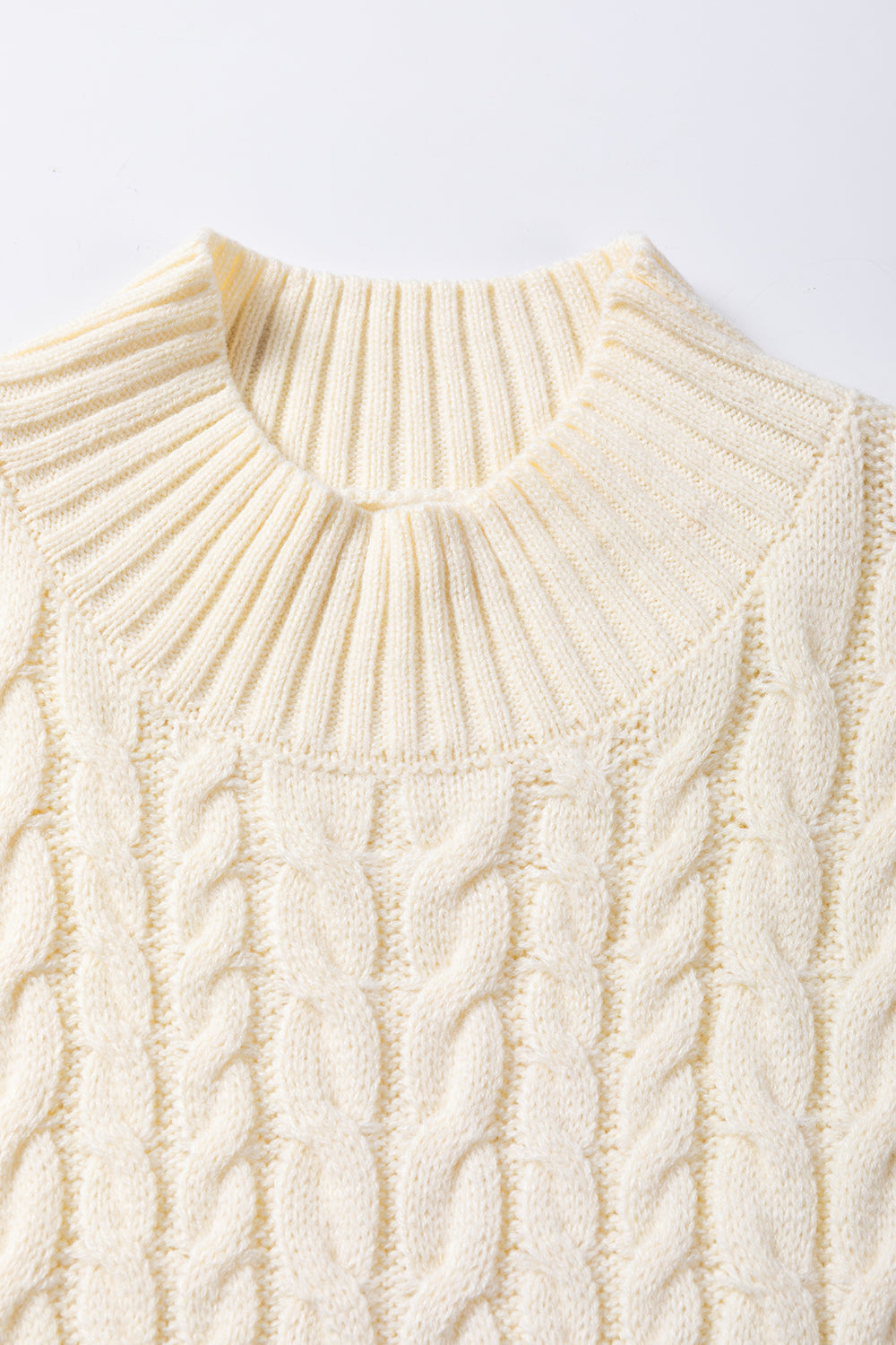 Cozy cable knit sweater vest in warm oatmeal shade, featuring a high neck and textured stitching for a classic, chic look.