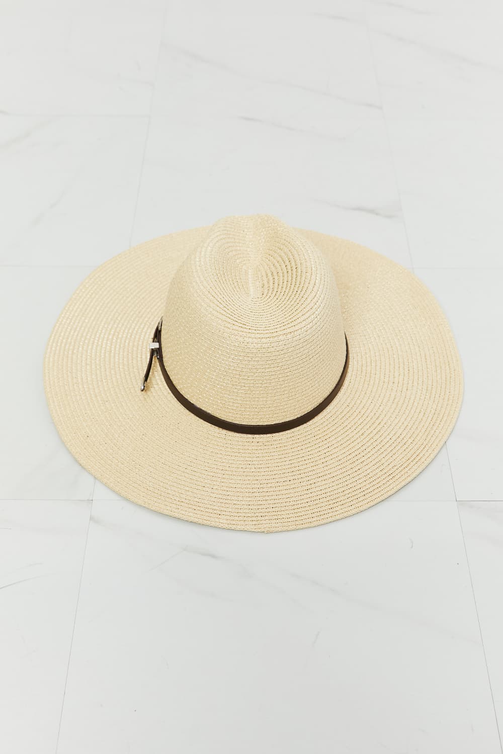 Elegant natural straw sun hat with leather trim, perfect summer accessory.