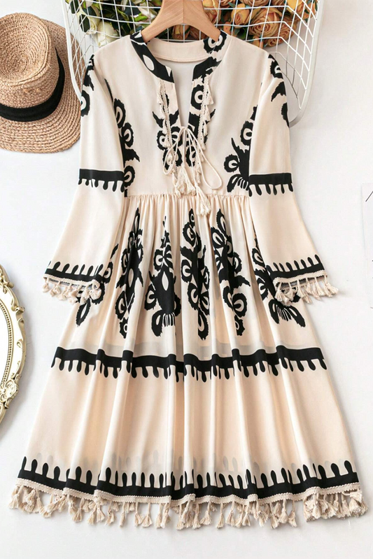 Stylish beige western pattern print dress with tasseled notch v-neck and mini length, displayed on a clothing rack with a straw hat.