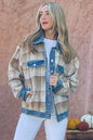 Woman wearing a plaid flannel jacket with denim details, standing in front of a beige wall with yarn in the foreground