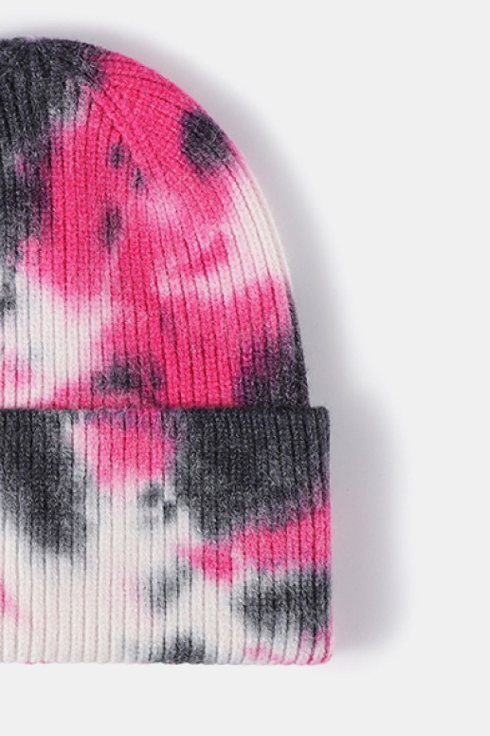 Vibrant tie-dye cuffed rib-knit beanie hat with a blend of pink and gray hues, showcasing a stylish and trendy accessory.