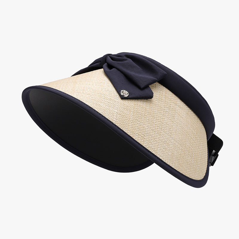 Stylish straw sun visor with black fabric accent, adjustable fit for comfortable wear on a sunny day.