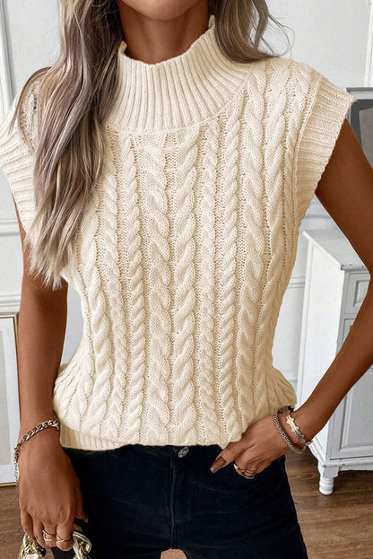 Cozy cable knit sweater vest in a warm oatmeal hue, featuring a high neck design and ribbed texture for a stylish, layered look.