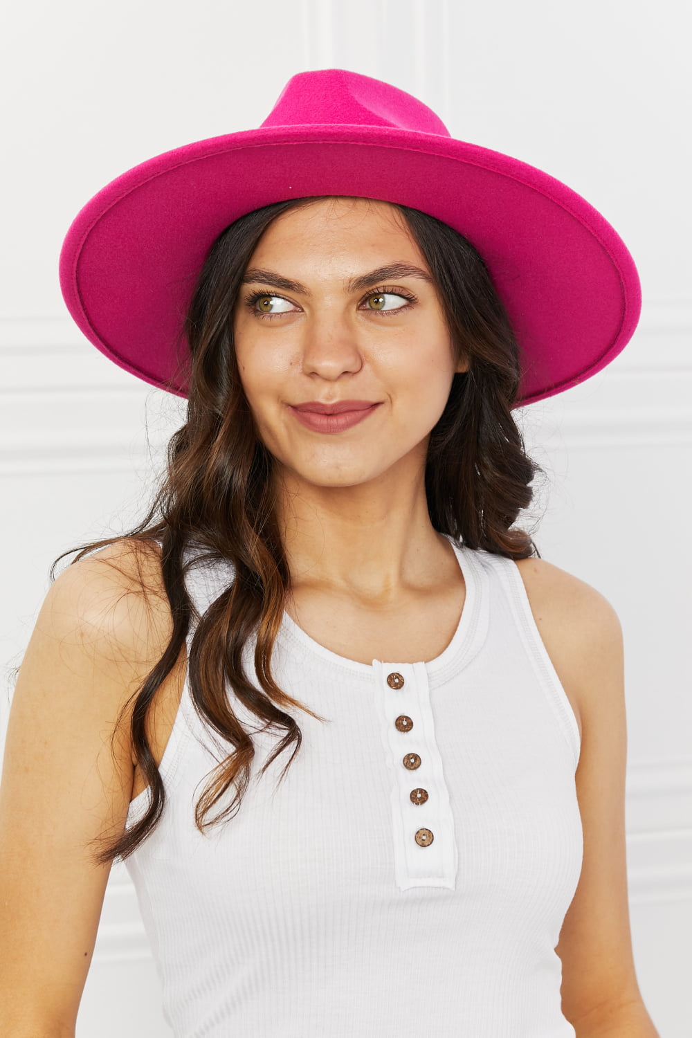 Vibrant pink fedora hat with a stylish woman's portrait in white background