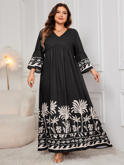 Plus-size black maxi dress with floral embroidery on the hem and bell sleeves.