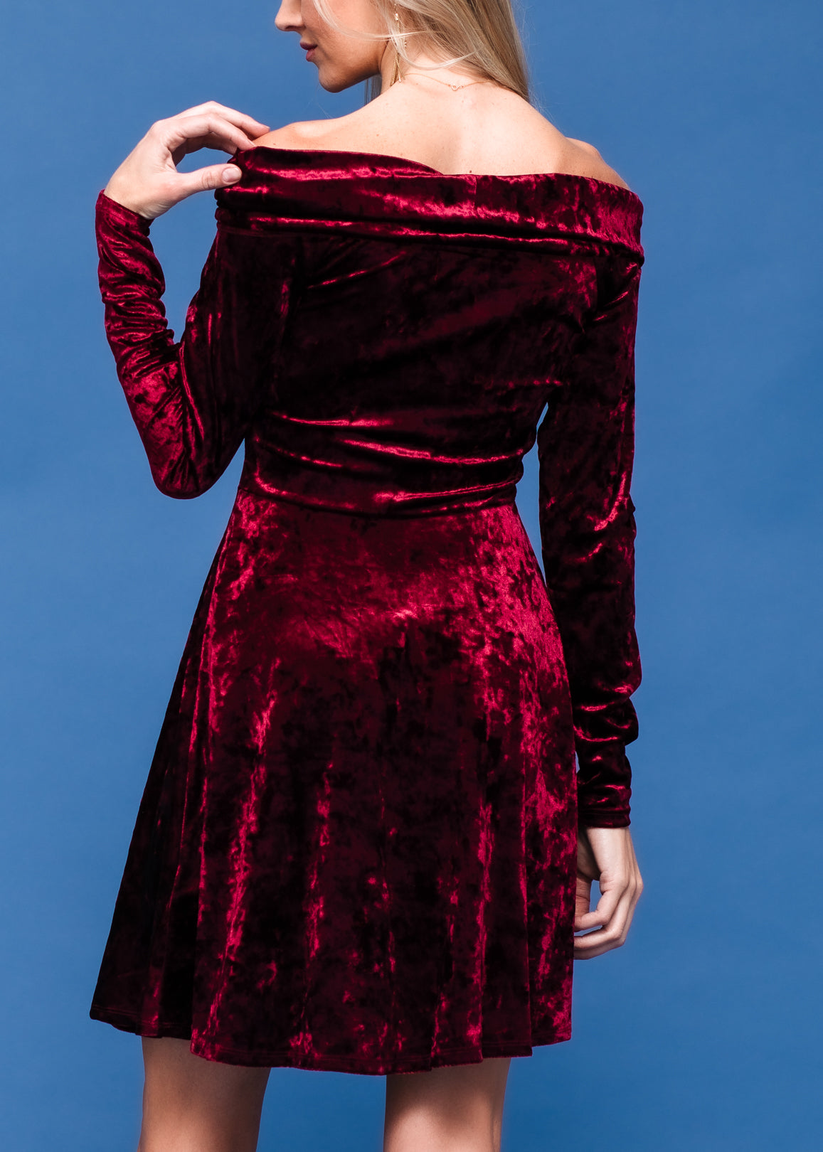 Elegant velvet dress with off-shoulder design, vibrant red color, and flared skirt