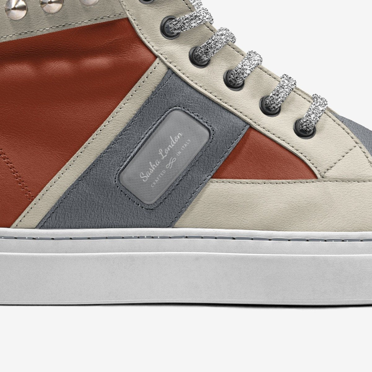 Sleek and stylish high-top sneakers with contrasting color panels, silver-tone eyelets, and a branded leather patch accent.