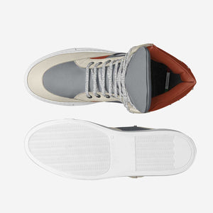 Sleek leather and suede sneakers with contrasting gray and orange accents, featuring a textured rubber sole for comfortable wear.