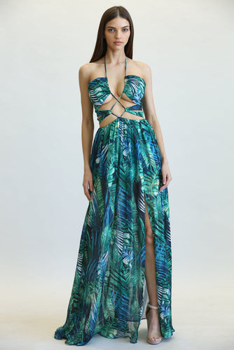 Tropical leaf print maxi dress with open midriff design, vibrant green and blue colors, form-fitting silhouette, sleeveless halter neckline, and high leg slit.