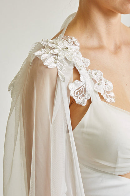 Beautiful white lace floral applique details on off-white cape sleeve of Reagan Dress by White Amphitryon, a women's clothing brand featured at LoveAdora fashion store.