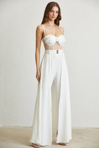 Elegant white jumpsuit with floral applique and gold button details, showcasing a stylish and modern design.