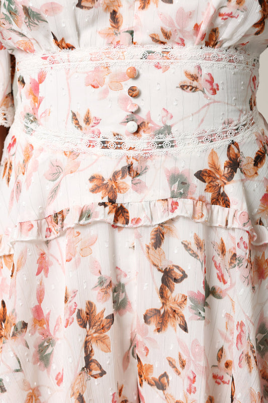 Delicate floral print romper from the Jenith collection by White Amphitryon. The whimsical design features soft pink and peach tones with delicate floral accents, creating a feminine and effortless look.