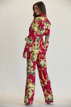 Load image into Gallery viewer, Ornate floral patterned women&#39;s blazer and pant set in vibrant red and gold tones, showcased on a female model standing against a plain background.