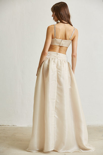 Elegant beige two-piece set featuring a form-fitting crop top and a flowing maxi skirt, ideal for evening or special occasions.