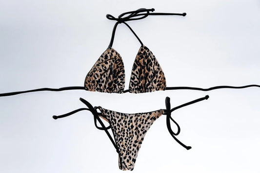 Stylish leopard-print bikini set featuring halter-style top and cheeky bottom with tie-side details