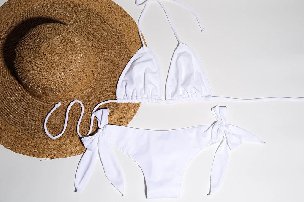 Stylish straw hat and white bikini set by White Amphitryon, featuring a tie-up design for a customizable fit.