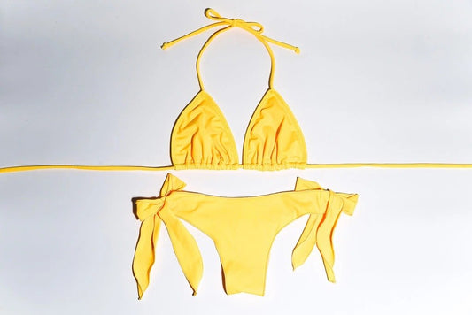 Vibrant yellow toddler swimwear with halter-style top and high-waisted bottoms on a white background.