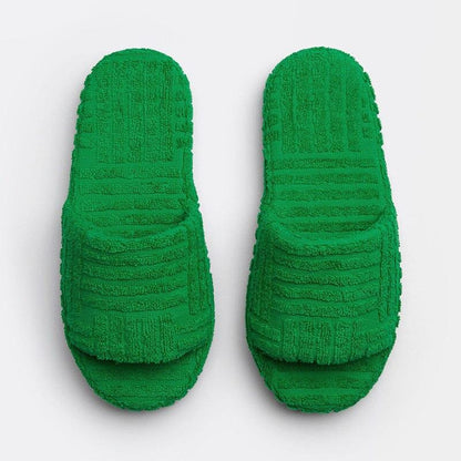 Plush green slippers with a textured, ribbed design for cozy and comfortable leisure wear.