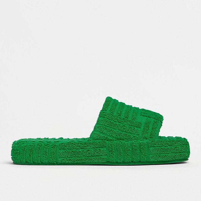 Plush green furry slippers offer cozy and comfortable leisure footwear.