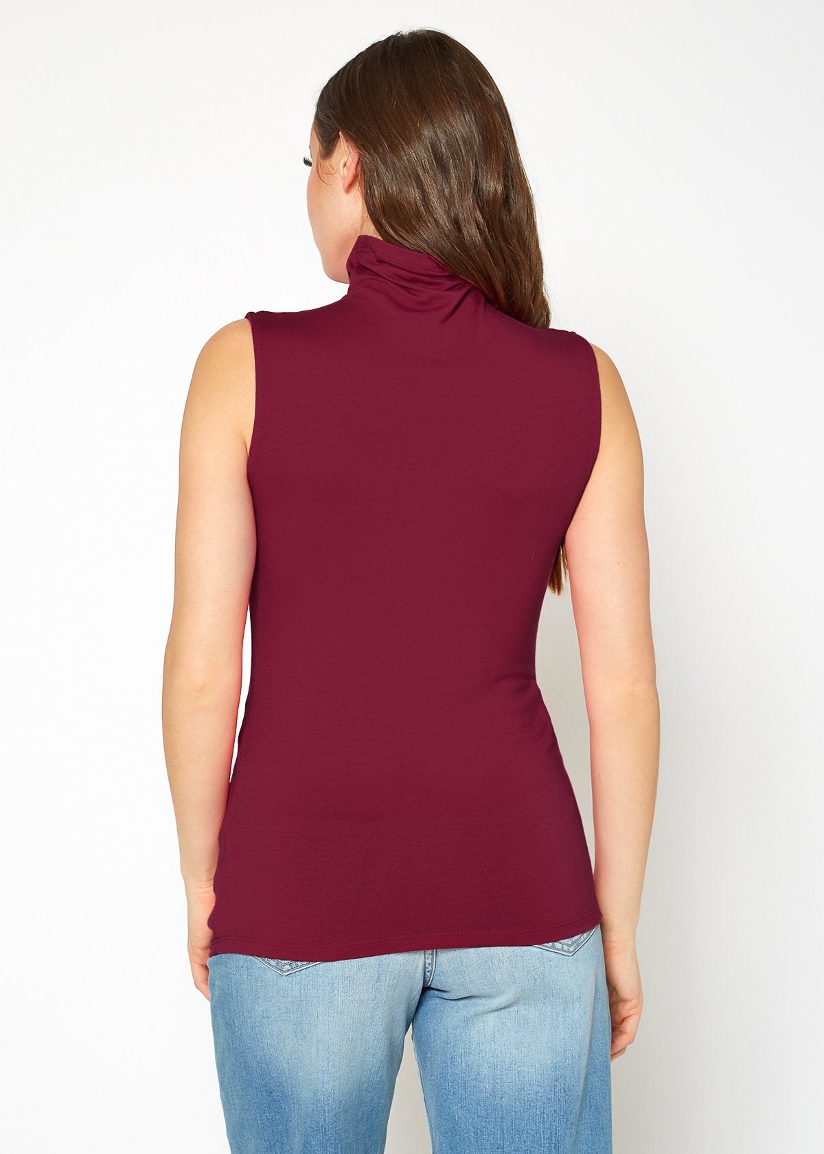 Fitted burgundy sleeveless top with high neckline, worn by a woman in the image.